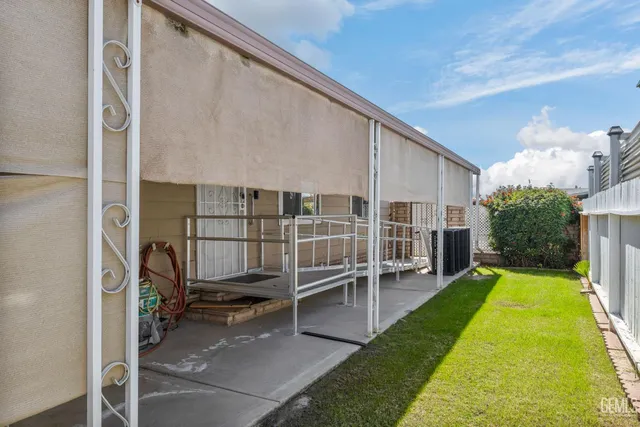 a view of house with backyard and furniture