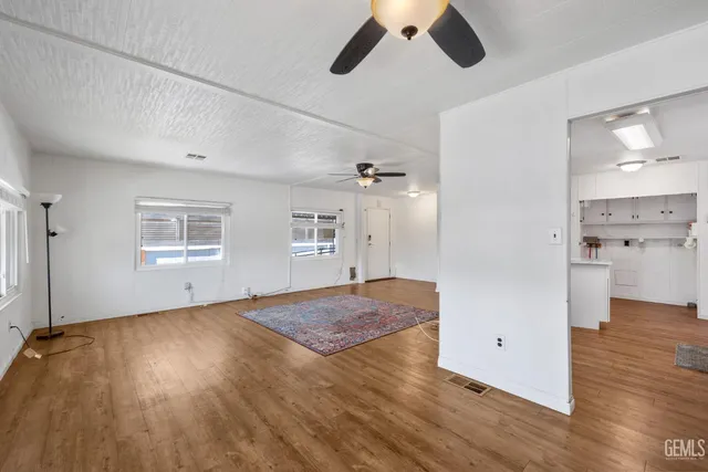 a view of empty room with wooden floor and window
