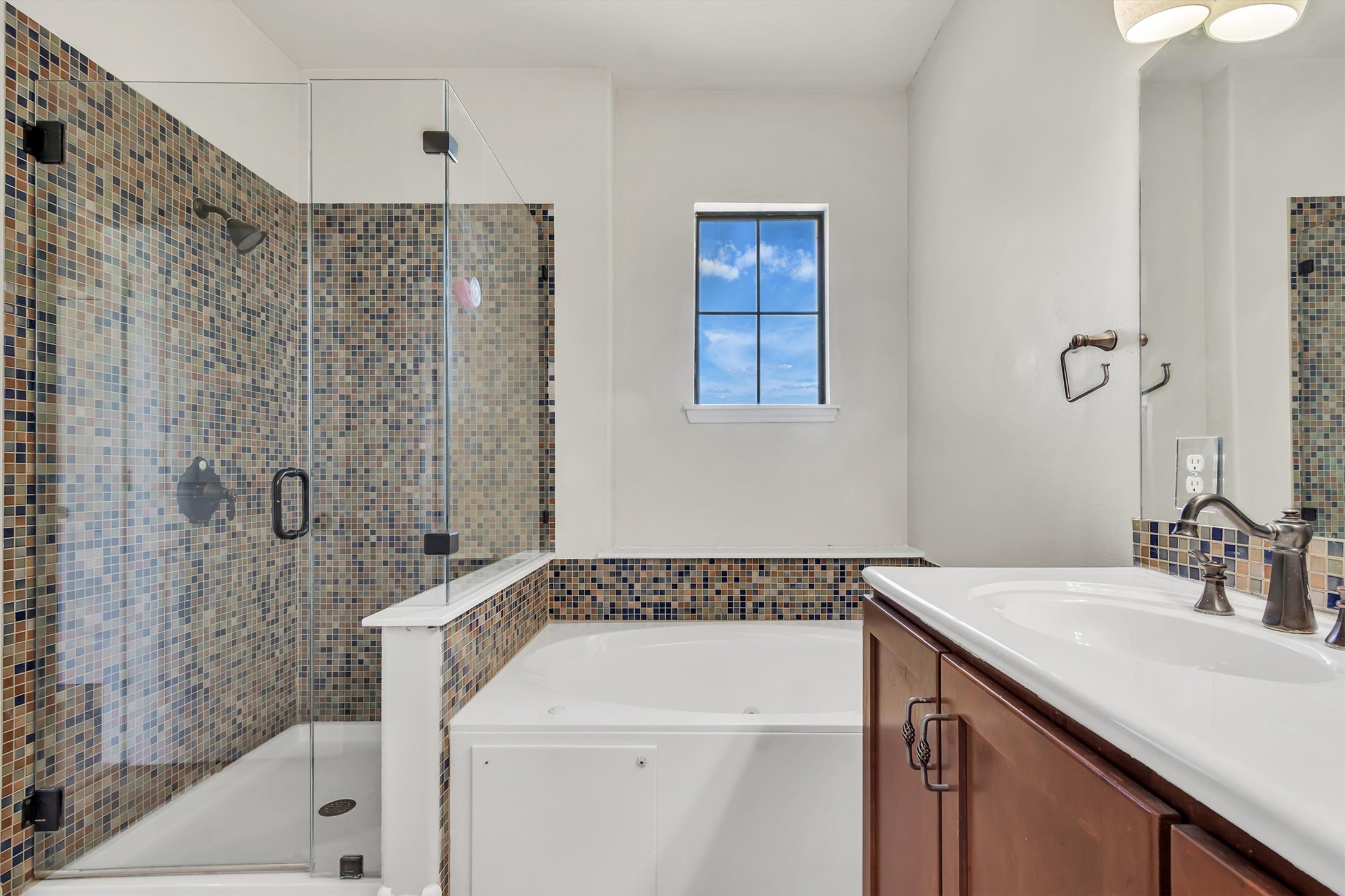 1010 Immanuel Road, Unit 103 Pflugerville, TX 78660 - Photo 23 of 30 A well-appointed bath features a tiled shower, soaking tub, and a vanity with ample counter space.