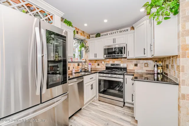 a kitchen with stainless steel appliances granite countertop a stove a sink and a refrigerator