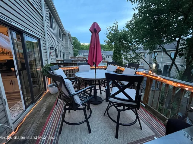 a view of a patio with a table and chairs and barbeque oven