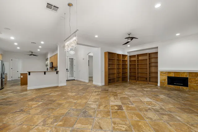 a view of an empty room with a fireplace and a window