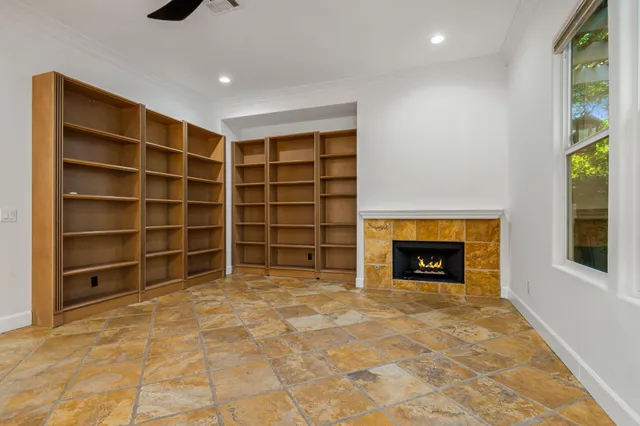 a view of an empty room with a window and fire place