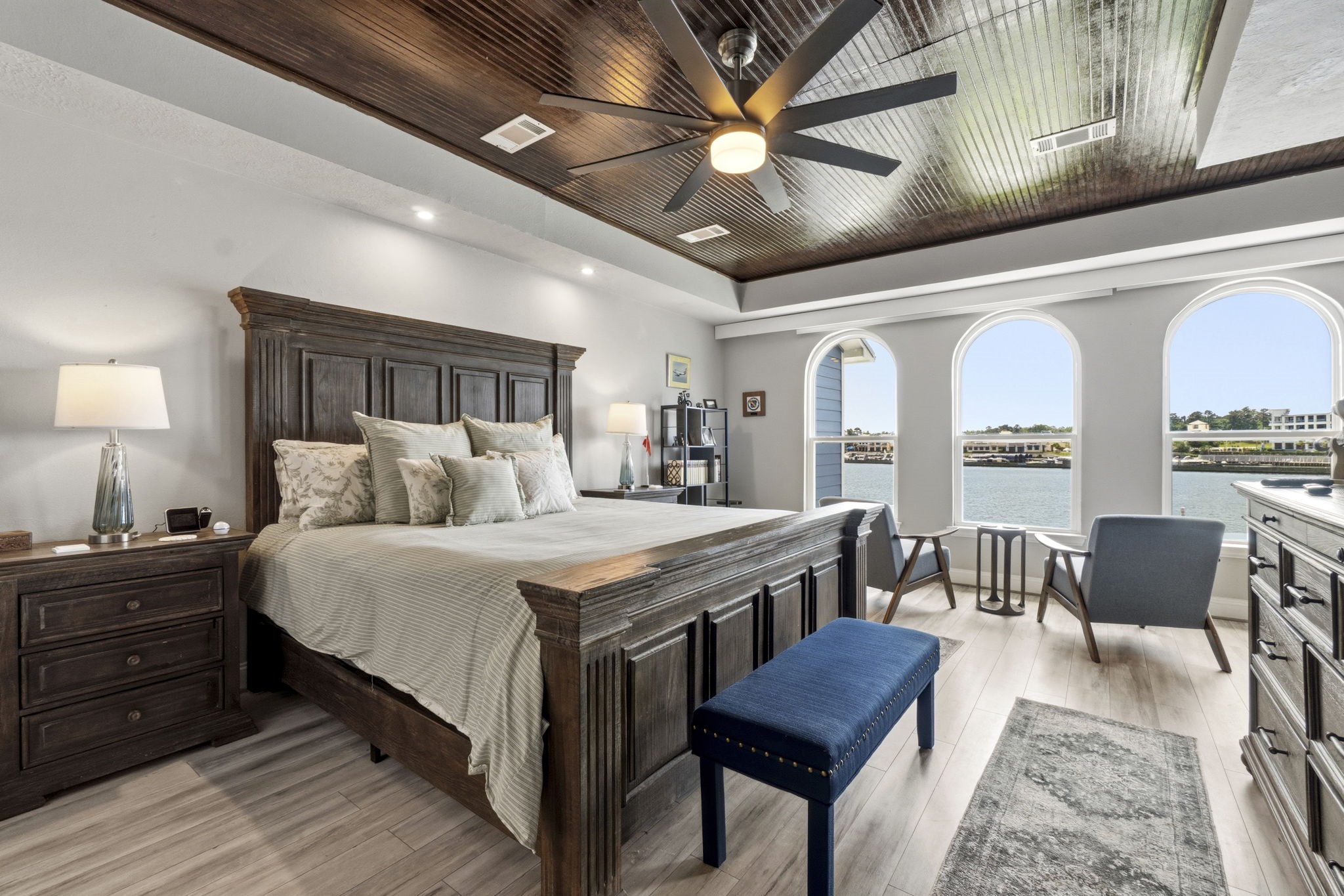 2 Key Harbour Conroe, TX 77356 - Photo 24 of 41 a spacious bedroom with a bed a chandelier and a bookshelf with wooden floor