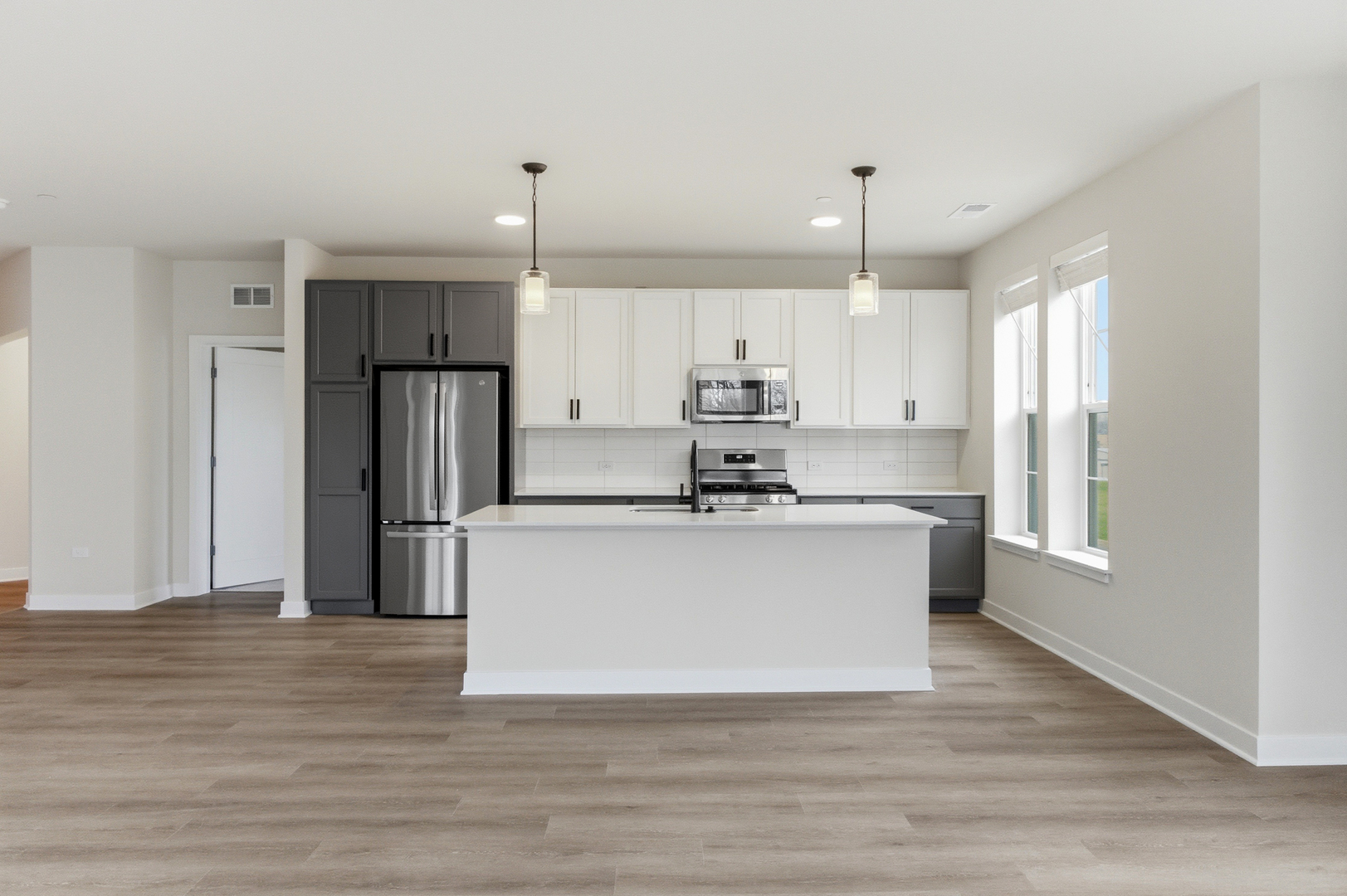 250 McHenry Road, Unit B2B3 Buffalo Grove, IL 60089 - Photo 30 of 33 a white kitchen with stainless steel appliances granite countertop a stove a refrigerator a sink and white cabinets with wooden floor