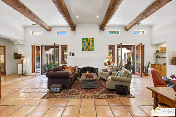 a living room with patio furniture and a rug
