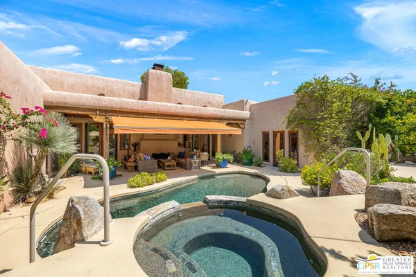 a view of a house with swimming pool and sitting area