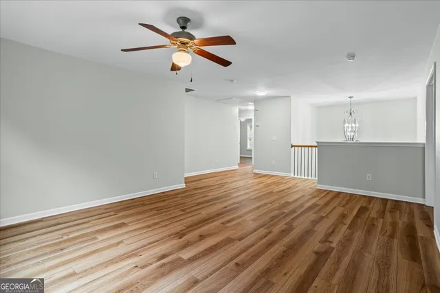 a view of a livingroom with an empty space wooden floor and windows