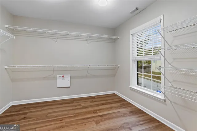 a view of empty room with wooden floor and fan