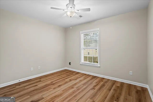 wooden floor in an empty room with a window