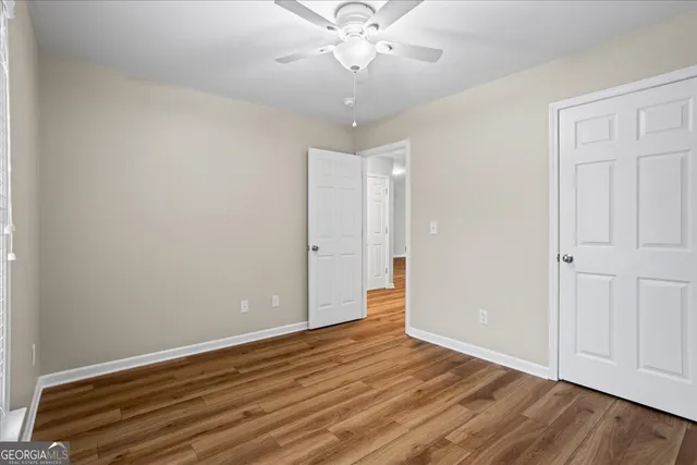 a view of room with window ceiling fan and hardwood floor
