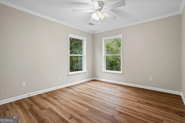 a view of empty room with wooden floor