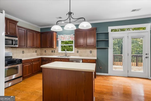 a kitchen with stainless steel appliances granite countertop a sink stove and cabinets