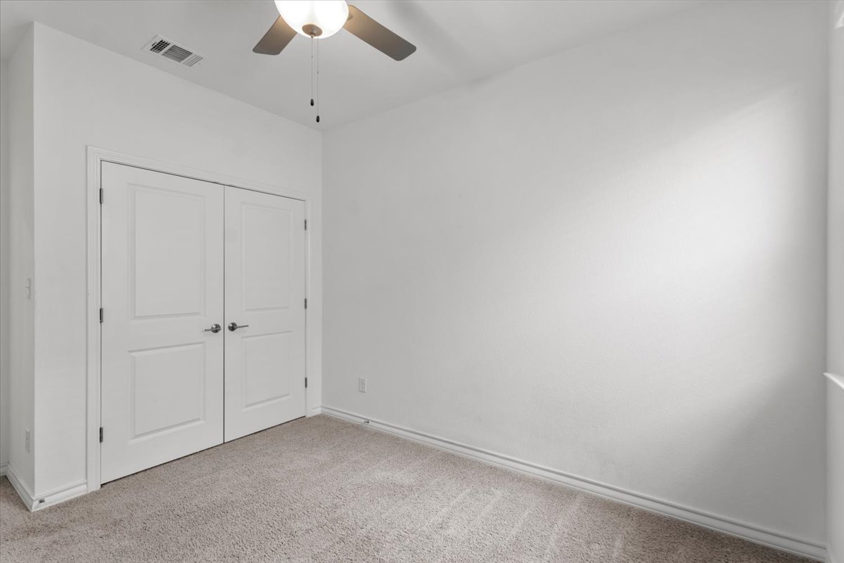500 Stinchcomb Road Hutto, TX 78634 - Photo 23 of 37 An inviting room features a practical ceiling fan, carpet flooring, and a pair of double doors.