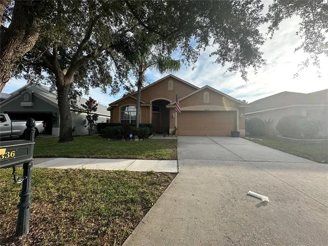 a front view of a house with a yard and trees