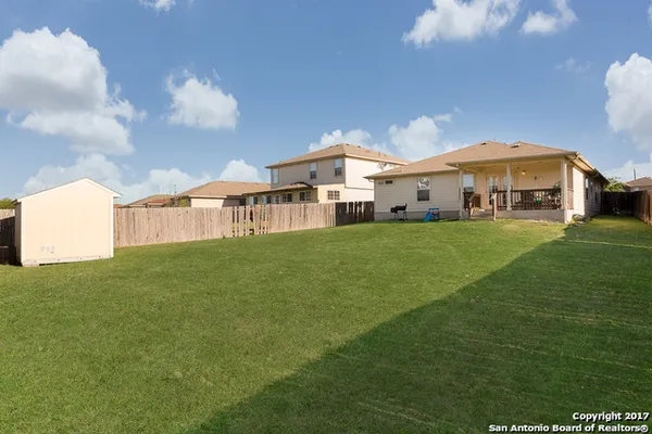 a view of a house with a big yard and large trees