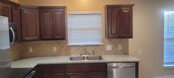 a kitchen with granite countertop white cabinets and sink