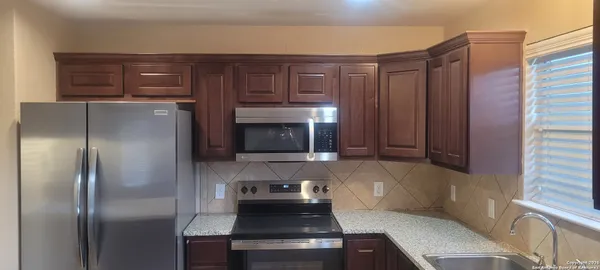 a kitchen with granite countertop stainless steel appliances and wooden cabinets