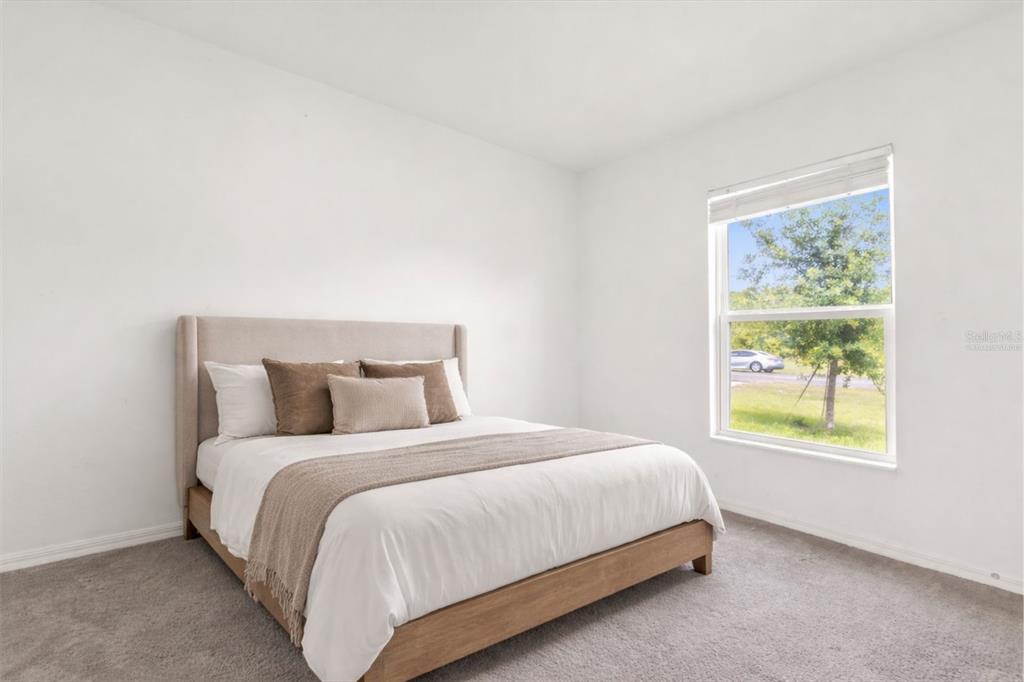 2134 Rio Grande Canyon Loop Poinciana, FL 34759 - Photo 8 of 22 a large bed sitting in a bedroom next to a window