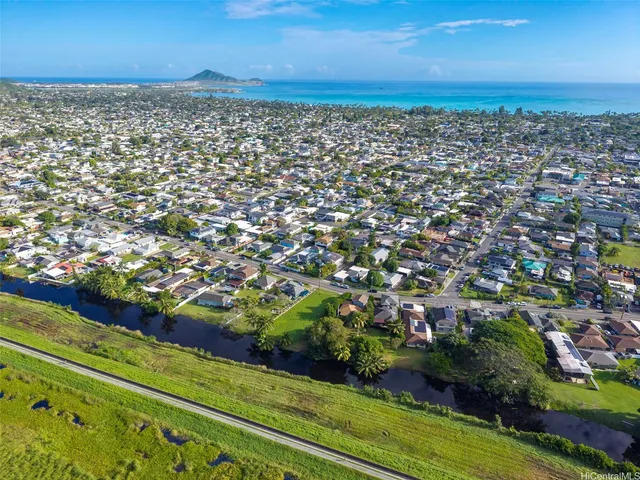 a view of backyard of house with outdoor area and trees