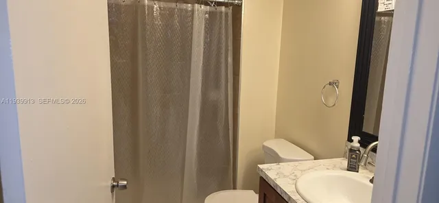 a bathroom with a sink and mirror with toilet