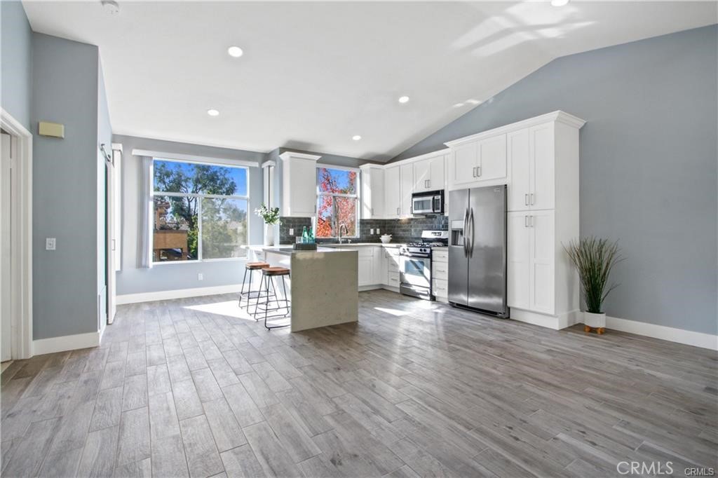 19431 Rue De Valore, Unit 49A Lake Forest, CA 92610 - Photo 11 of 23 a kitchen with stainless steel appliances a refrigerator and wooden floor