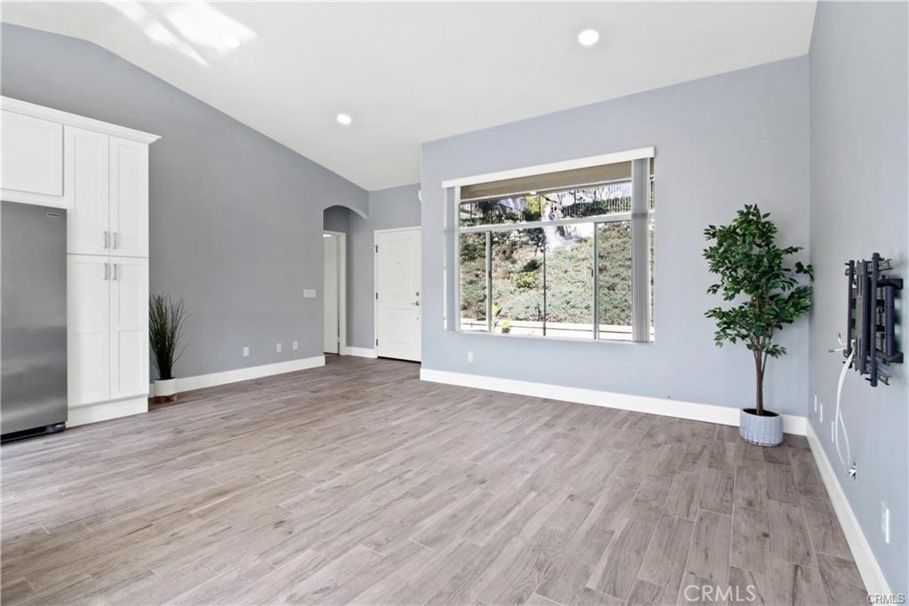 19431 Rue De Valore, Unit 49A Lake Forest, CA 92610 - Photo 4 of 23 an empty room with wooden floor and windows