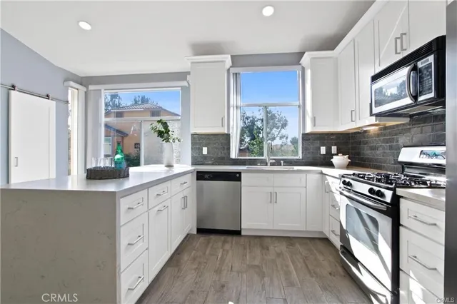 a kitchen with white cabinets sink and stainless steel appliances