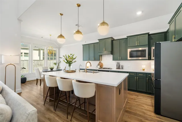 a kitchen with a sink a stove and chairs