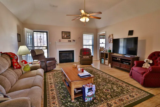 a living room with furniture a flat screen tv and a fireplace