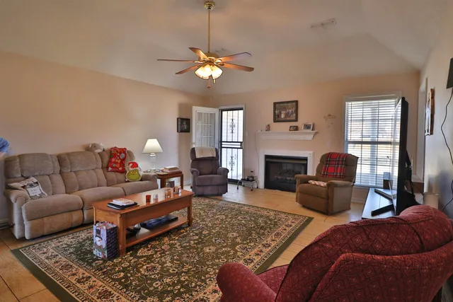 a living room with furniture a fireplace and window