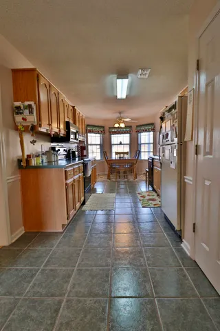 a large kitchen with stainless steel appliances granite countertop a large stove a sink dishwasher and a refrigerator