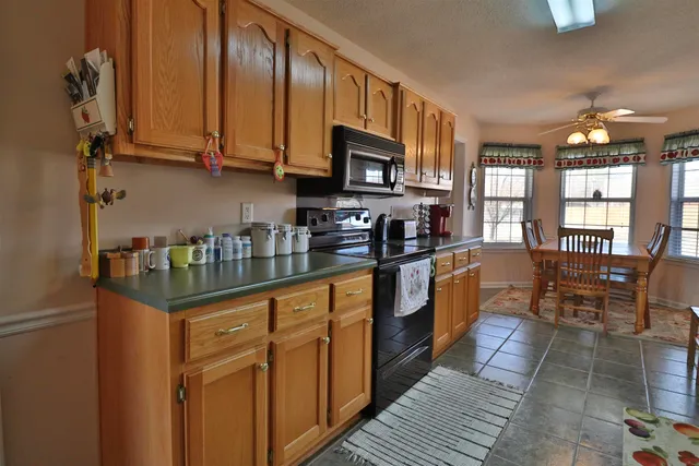 a kitchen with stainless steel appliances granite countertop a stove top oven a sink dishwasher and cabinets with wooden floor