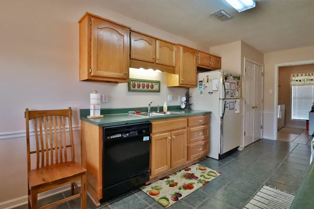 a kitchen with stainless steel appliances granite countertop a refrigerator stove and sink