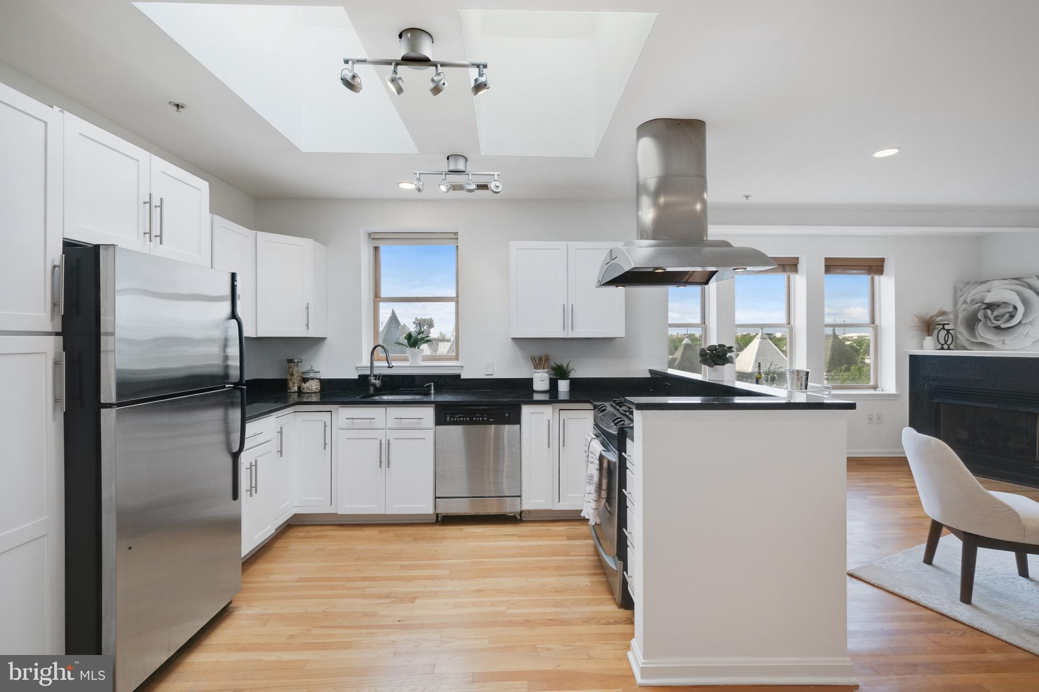 70 Rhode Island Avenue Northwest, Unit 502 Washington, DC 20001 - Photo 11 of 36 a kitchen with stainless steel appliances a refrigerator a sink dishwasher a stove and white cabinets with wooden floor