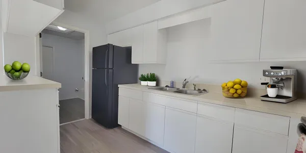 a kitchen with stainless steel appliances a sink a refrigerator and a counter top space