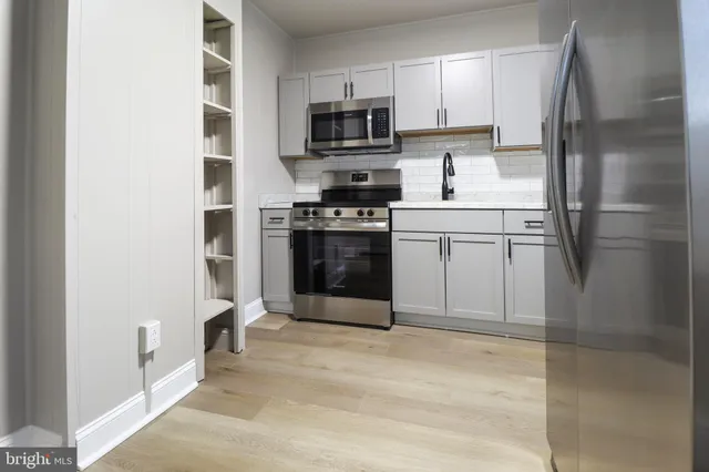 a kitchen with stainless steel appliances granite countertop a refrigerator stove and microwave