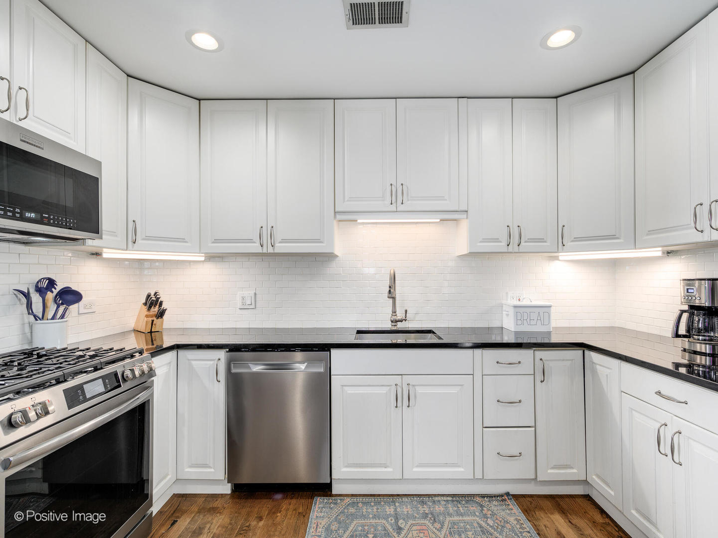 3903 North Seeley Avenue, Unit 3 Chicago, IL 60618 - Photo 10 of 20 a kitchen with granite countertop white cabinets and stainless steel appliances