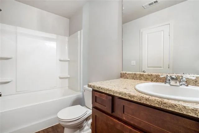 a bathroom with a granite countertop sink a toilet and bathtub