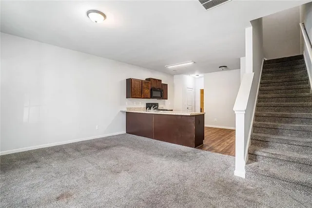 a view of a kitchen with wooden floor and electronic appliances