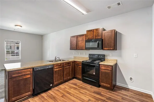 a kitchen with stainless steel appliances granite countertop a sink stove and microwave