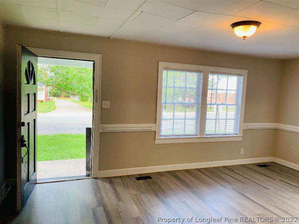 203 Hillsborough Road Carrboro, NC 27510 - Photo 6 of 12 a view of an empty room with wooden floor and a window
