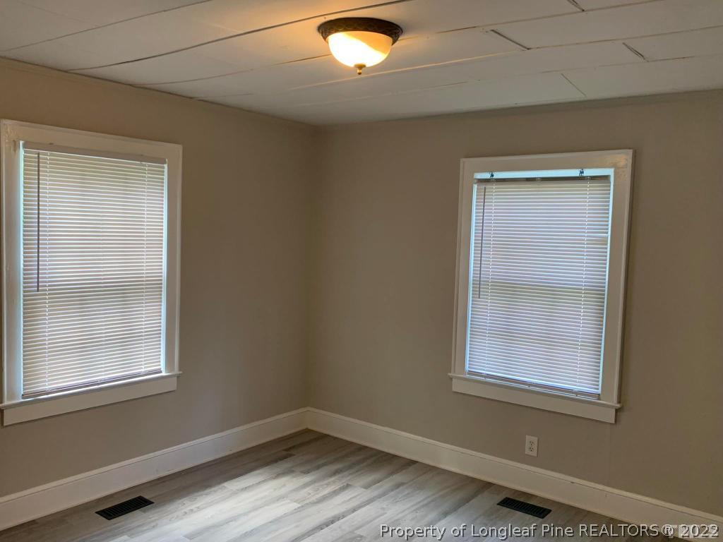 203 Hillsborough Road Carrboro, NC 27510 - Photo 8 of 12 a view of an empty room with wooden floor and a window