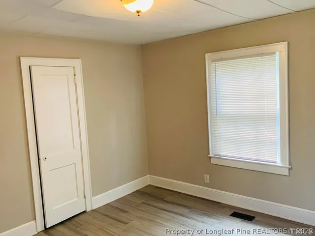 an empty room with wooden floor and a window