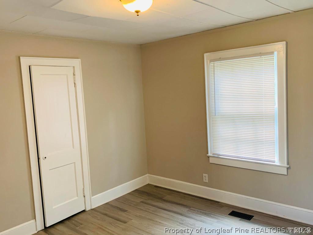 203 Hillsborough Road Carrboro, NC 27510 - Photo 9 of 12 an empty room with wooden floor and a window