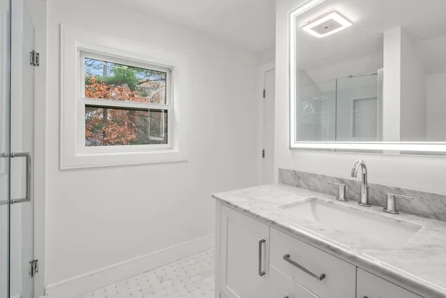 a bathroom with a granite countertop sink mirror and vanity