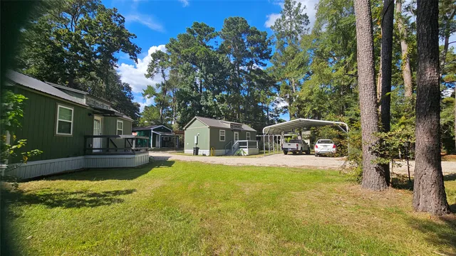 a front view of a house with a garden and trees