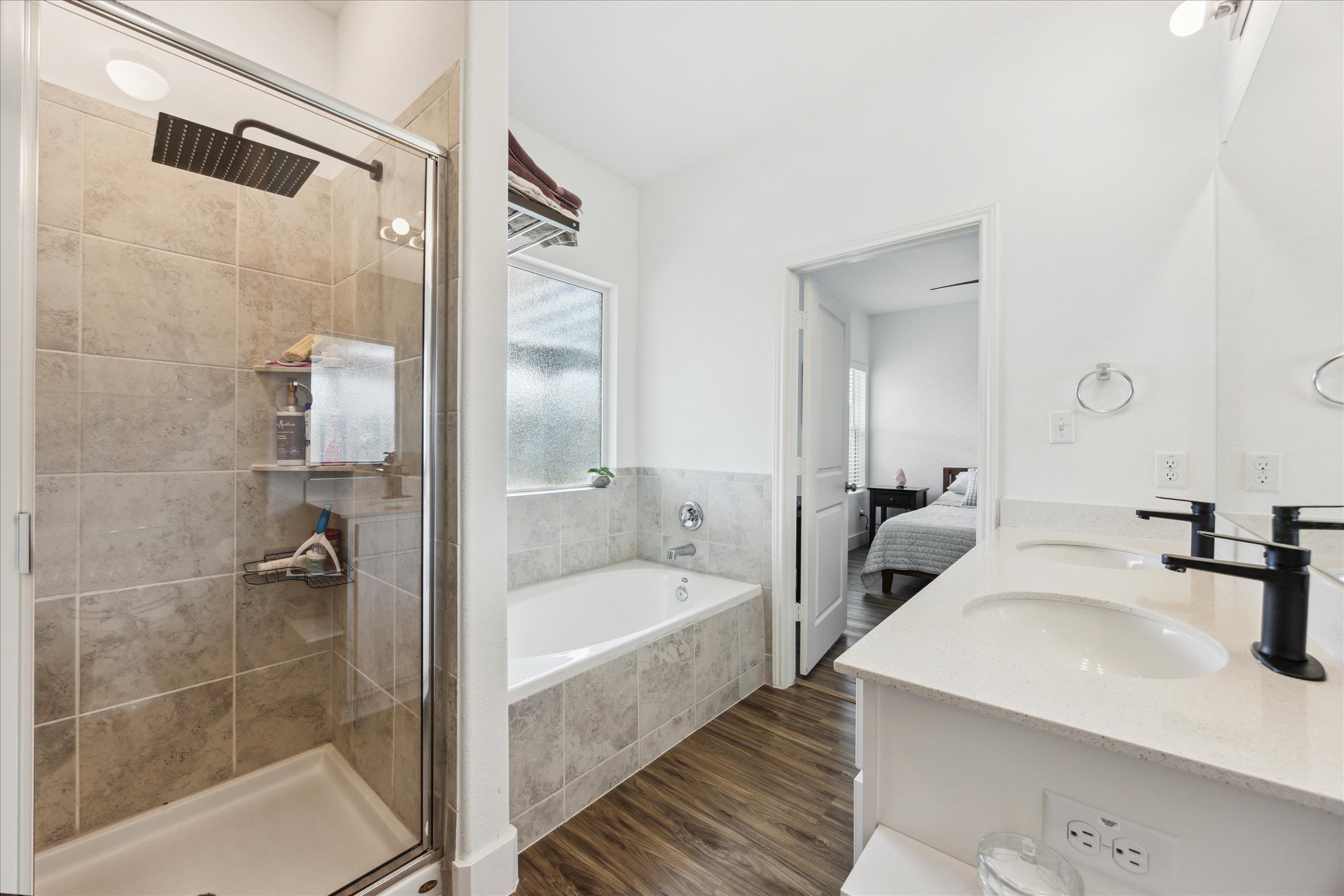 700 Legends Lane Georgetown, TX 78628 - Photo 16 of 31 Bathroom featuring a bath, a shower stall, wood finished floors, double vanity, and ensuite bath
