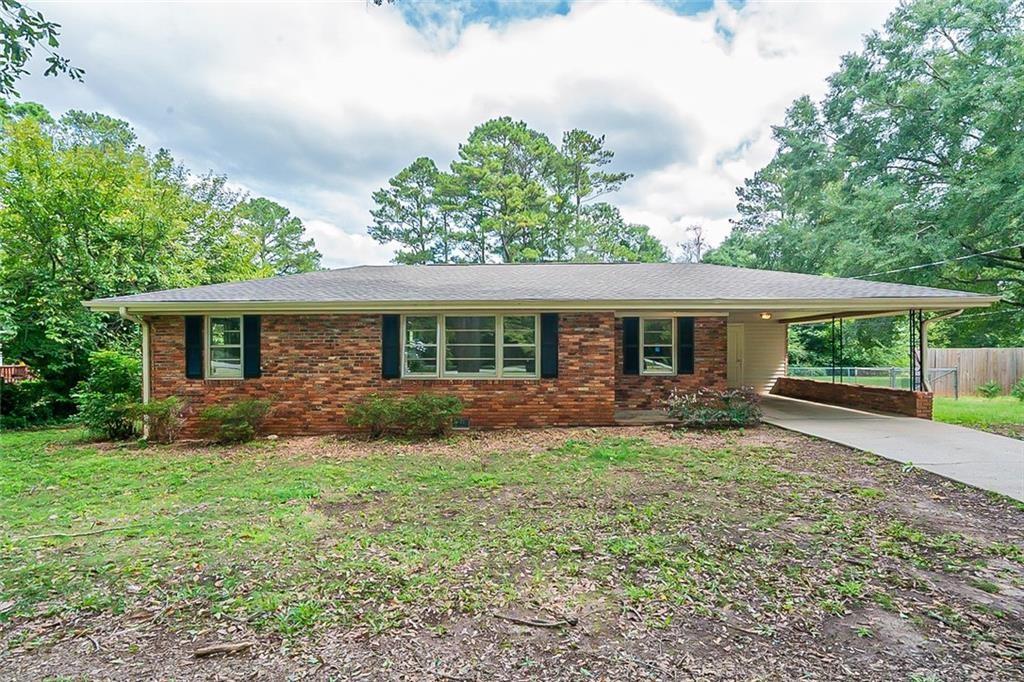 5167 Hiram Lithia Springs Road Southwest Powder Springs, GA 30127 - Photo 1 of 1 a front view of house with yard and green space