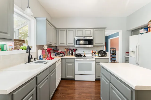 a kitchen with a sink stove top oven and refrigerator